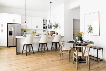 A kitchen and dining area with white cabinets and a table and chairs